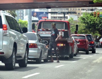 Los limpiavidrios se ocultan y salen en las avenidas de la capital